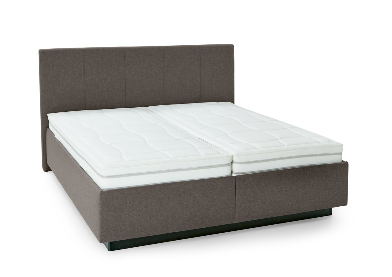 Gestoffeerd bed in zijaanzicht met grijs hoofdeinde en wit matras