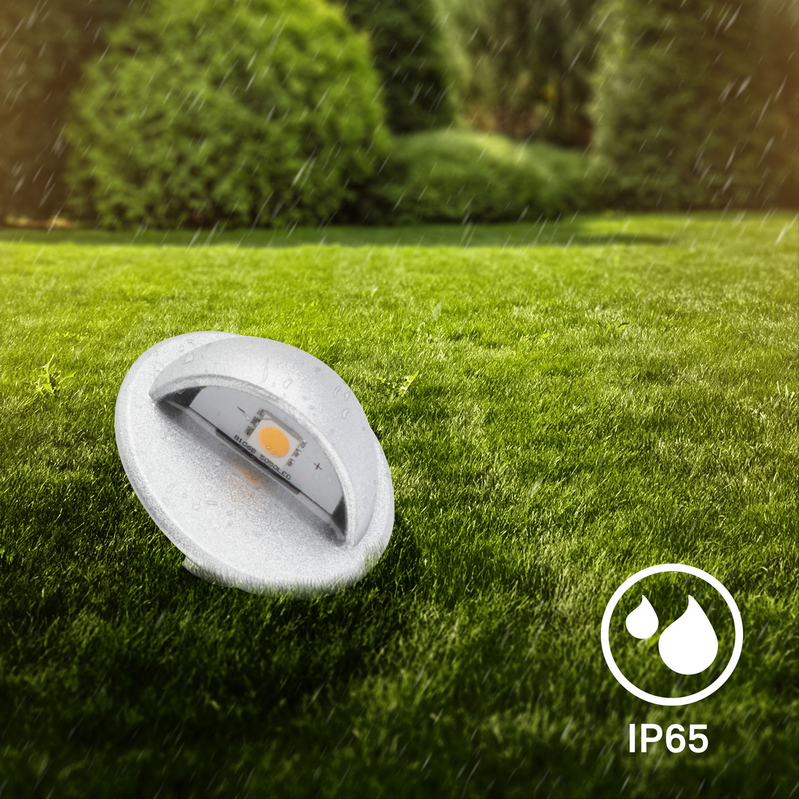 Einbaulicht im Freien auf einer Rasenfläche bei Regen, IP65 zertifiziert, seitliche Perspektive