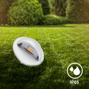 Einbaulicht im Freien auf einer Rasenfläche bei Regen, IP65 zertifiziert, seitliche Perspektive