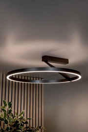 Moderne runde LED-Deckenleuchte in Ringform aus schwarzem Metall mit warmweißem Licht, an der Decke montiert – Ansicht leicht von unten im Innenraum