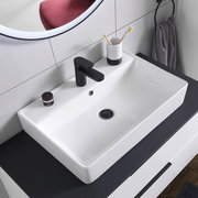 Moderner Waschtisch mit schwarzem Wasserhahn, Zahnputzbecher und Handtuch, aus der Vogelperspektive.