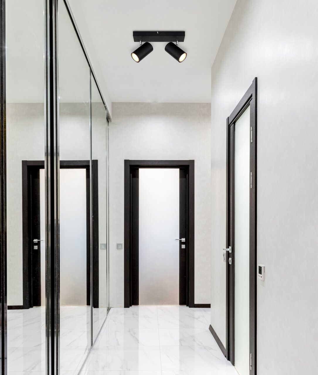 Globo Lighting Strahler ROBBY Deckenstrahler mit zwei schwarzen Leuchten in einem modernen Flur, Perspektive von unten.