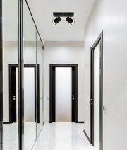 Deckenstrahler mit zwei schwarzen Leuchten in einem modernen Flur, Perspektive von unten.
