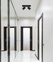 Deckenstrahler mit zwei schwarzen Leuchten in einem modernen Flur, Perspektive von unten.