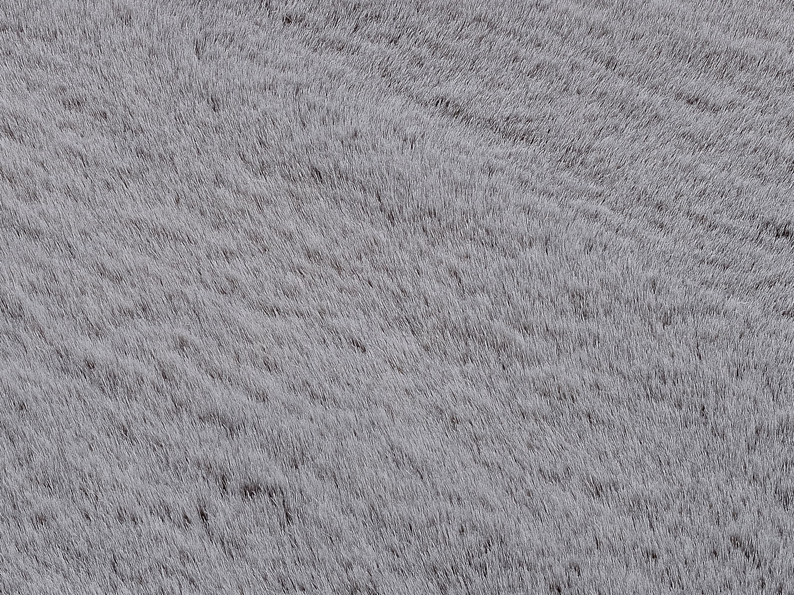 Nahaufnahme eines grauen Fellteppichs mit weicher Textur