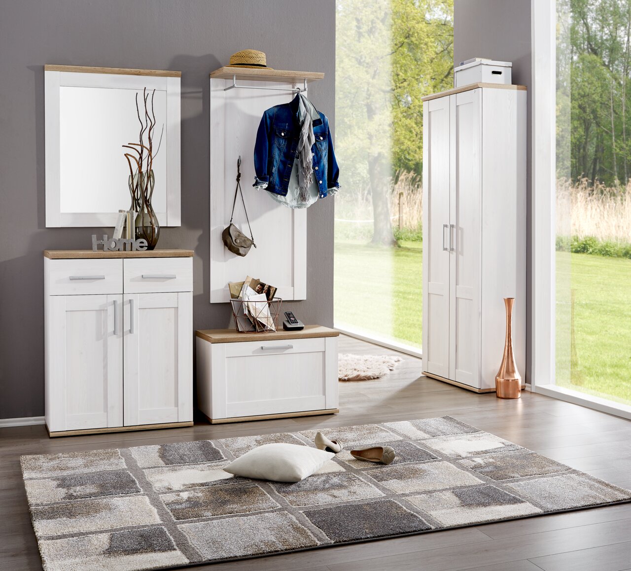 Moderne Garderobeneinrichtung in heller Holzoptik mit Spiegel, Garderobenpaneel, Schuhschrank und hohem Schrank, seitliche Perspektive.