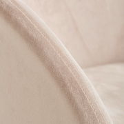 Nahaufnahme eines Sessels mit weichem, beigem Stoffbezug und sichtbarer Naht, seitliche Perspektive.