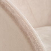 Nahaufnahme eines Sessels mit weichem, beigem Stoffbezug und sichtbarer Naht, seitliche Perspektive.