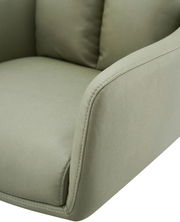 Nahaufnahme eines grünen Armlehnstuhls aus Stoff, Fokus auf die Armlehne und Sitzfläche, seitliche Perspektive