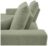 Nahaufnahme einer grünen, gerippten Sofaecke mit Kissen, seitliche Perspektive