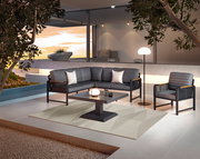 Moderne Loungegarnitur mit grauen Polstern und schwarzem Gestell, bestehend aus Sofa, Sessel und Tisch, auf einer Terrasse mit Blick auf den Sonnenuntergang.