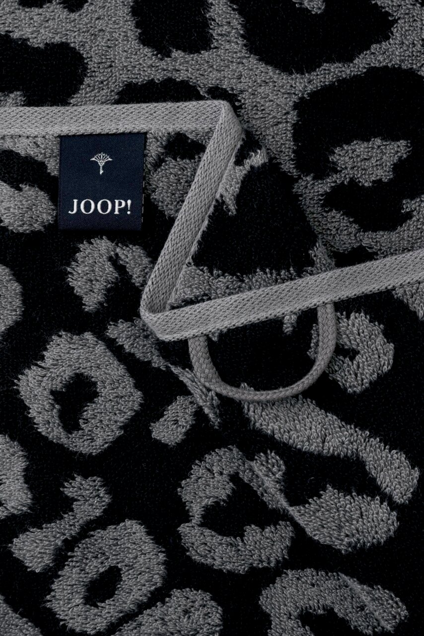 Nahaufnahme eines grauen Gästetuchs mit schwarzem Leopardenmuster und einem Joop-Label.
