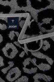 Nahaufnahme eines grauen Gästetuchs mit schwarzem Leopardenmuster und einem Joop-Label.