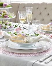 Elegantes Tafelset Beat Weiß 12-tlg. auf einem festlich gedeckten Tisch mit Blumen und Sektgläsern, seitliche Perspektive.