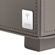 Close-up van een grijs dienblad met het Joop-logo op een metalen inlegstuk, vanuit een zijdelingse hoek gefotografeerd.