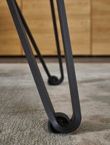 Nahaufnahme eines Tischbeins mit modernem Design und Rollen, Perspektive von unten.