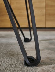 Nahaufnahme eines Tischbeins mit modernem Design und Rollen, Perspektive von unten.