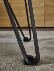 Nahaufnahme eines Tischbeins mit modernem Design und Rollen, Perspektive von unten.