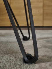Nahaufnahme eines Tischbeins mit modernem Design und Rollen, Perspektive von unten.
