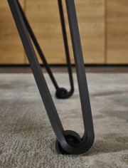 Nahaufnahme eines Tischbeins mit modernem Design und Rollen, Perspektive von unten.