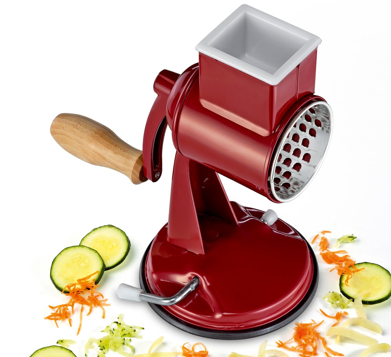 Rote Trommelreibe CLASSIC mit Holzgriff, seitliche Perspektive, umgeben von geriebenem Gemüse.