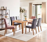 Esszimmer mit einem Holztisch und sechs gepolsterten Stühlen in Grau und Rosa, seitliche Perspektive