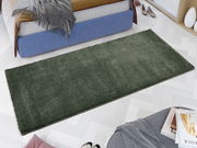 Grüner Uni-Teppich in einem modernen Schlafzimmer, aus der Vogelperspektive fotografiert.