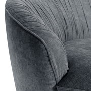 Nahaufnahme eines grauen, runden Megasofas mit weicher Polsterung und eleganten Falten im Stoff, seitliche Perspektive.