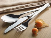 Elegantes Besteck-Set bestehend aus Löffel, Messer und Gabel in Nahaufnahme auf einem Holztisch, begleitet von Physalis-Früchten und einem beigen Stofftuch.