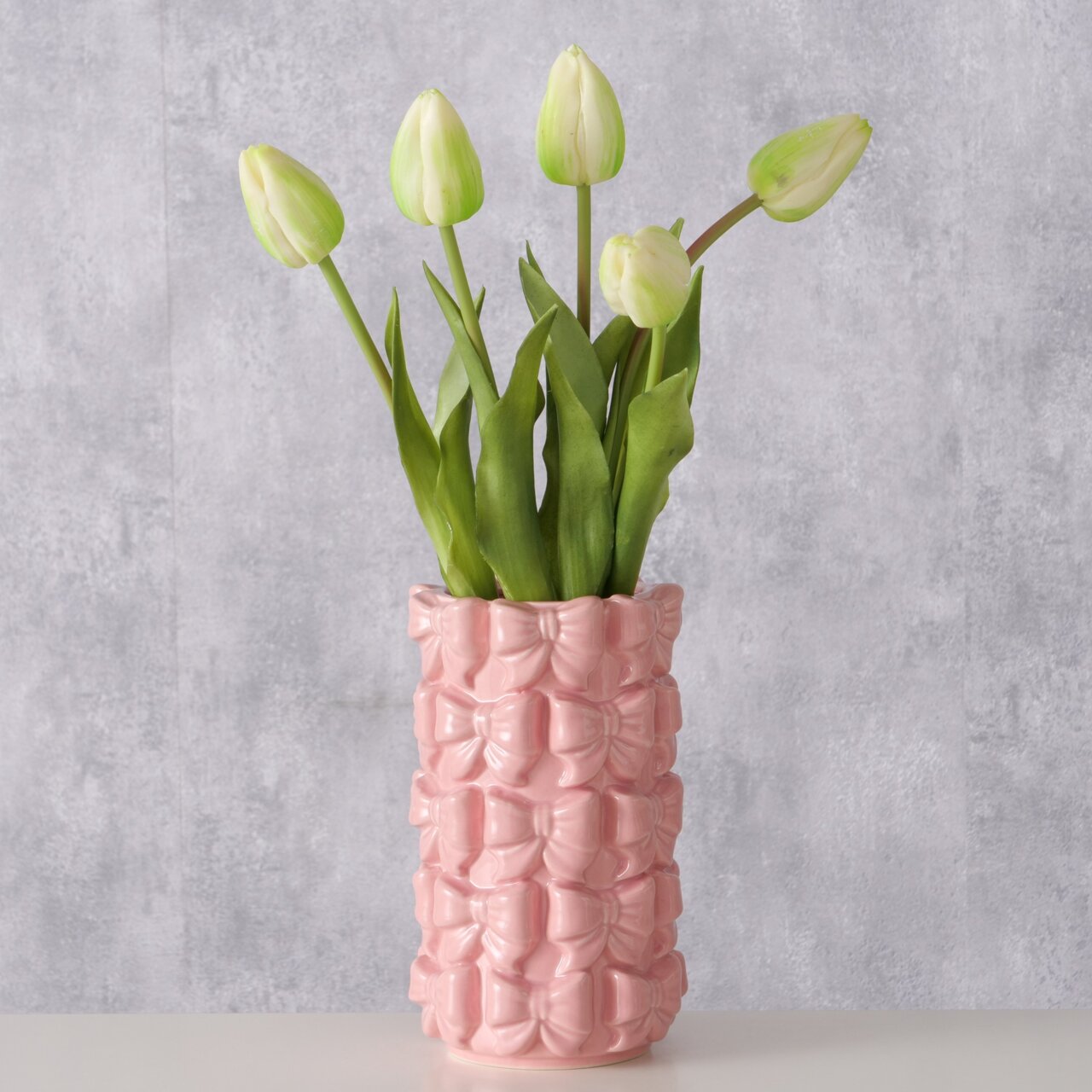 Rosa Vase mit Schleifenmuster, gefüllt mit weißen und grünen Tulpen, seitliche Perspektive
