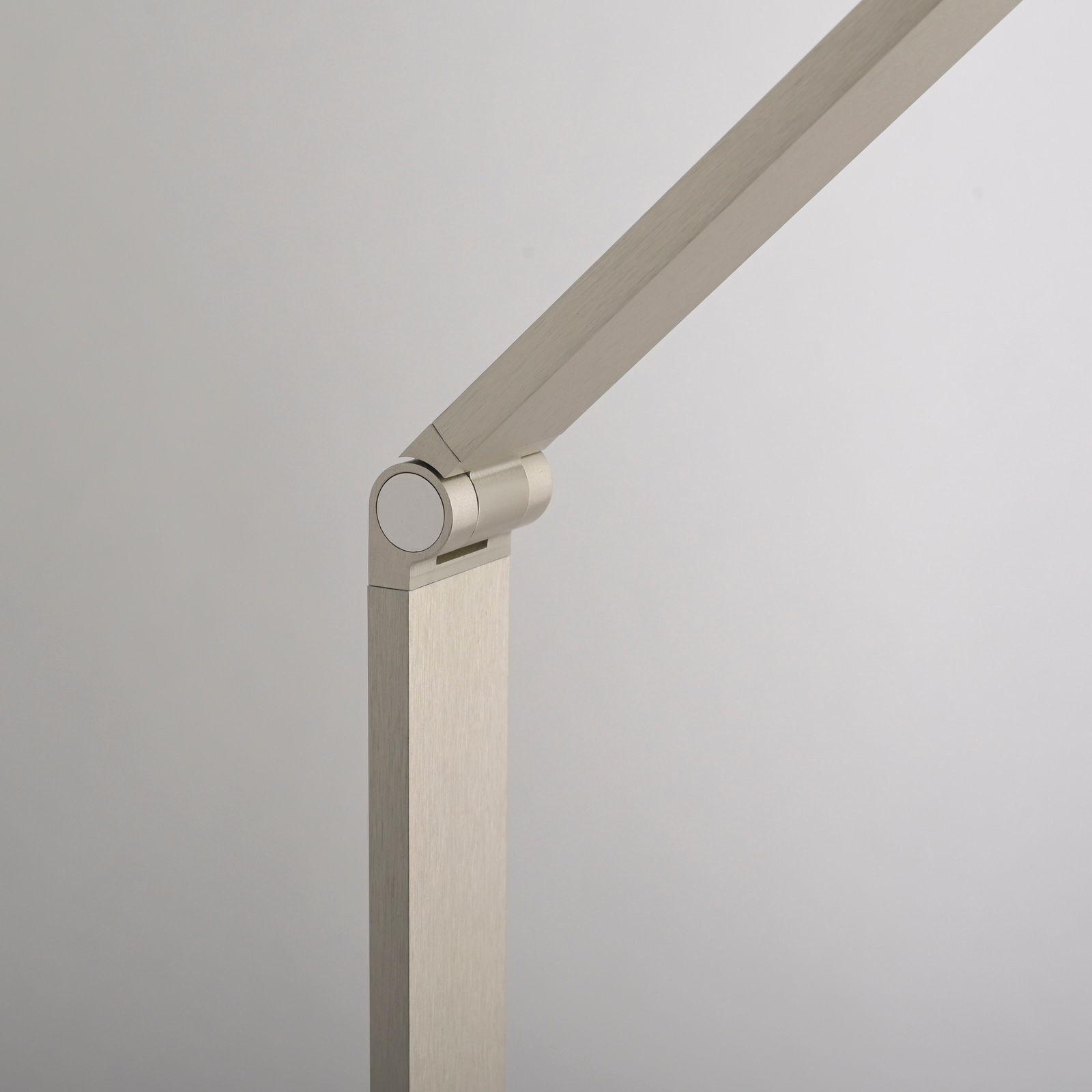 Detailansicht einer modernen LED-Tischleuchte mit schwenkbarem Arm in gebürstetem Metall.