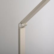 Detailansicht einer modernen LED-Tischleuchte mit schwenkbarem Arm in gebürstetem Metall.