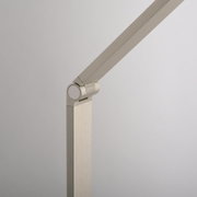 Detailansicht einer modernen LED-Tischleuchte mit schwenkbarem Arm in gebürstetem Metall.