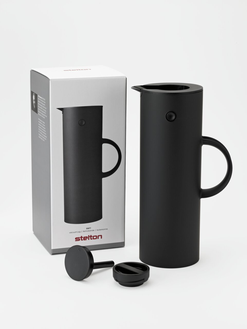 Schwarze Isolierkanne mit abgerundeter Form und Griff, abgebildet aus einer leicht seitlichen Perspektive neben ihrer Verpackung.
