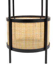 Nahaufnahme eines Beistelltisches mit schwarzem Metallrahmen und geflochtenem Rattan-Design.