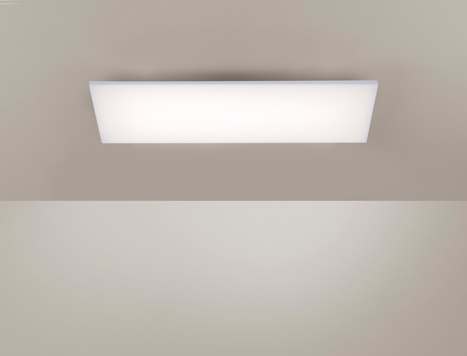Rechteckige, flache LED-Deckenleuchte mit weißer, opaler Abdeckung an einer hellen Decke, Ansicht von unten (Untersicht).