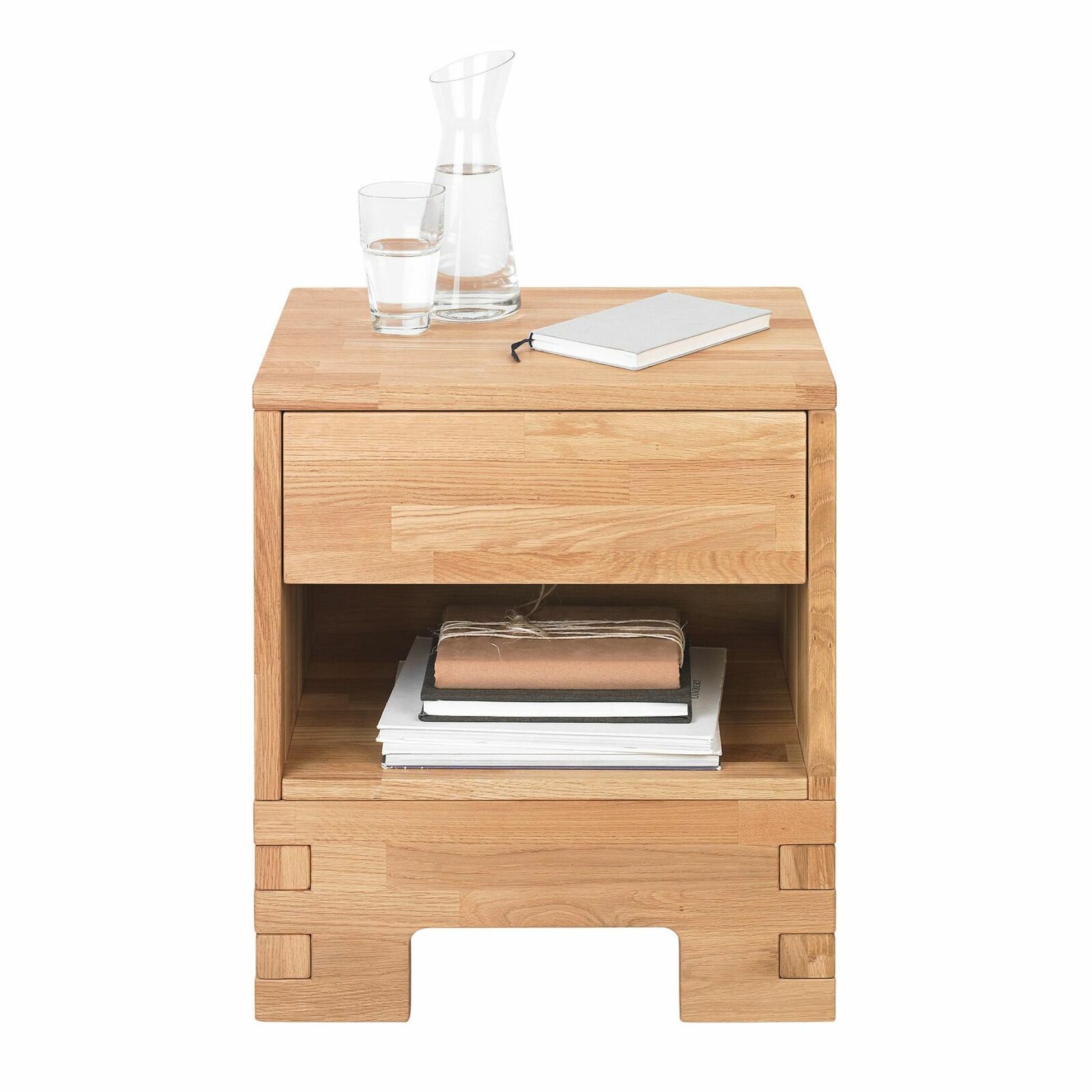 Linea Natura Nachtkommode COUNTRY Nachtkommode aus Holz mit Schublade und offenem Fach, frontal fotografiert, dekoriert mit einer Karaffe, einem Glas Wasser und einem Notizbuch.
