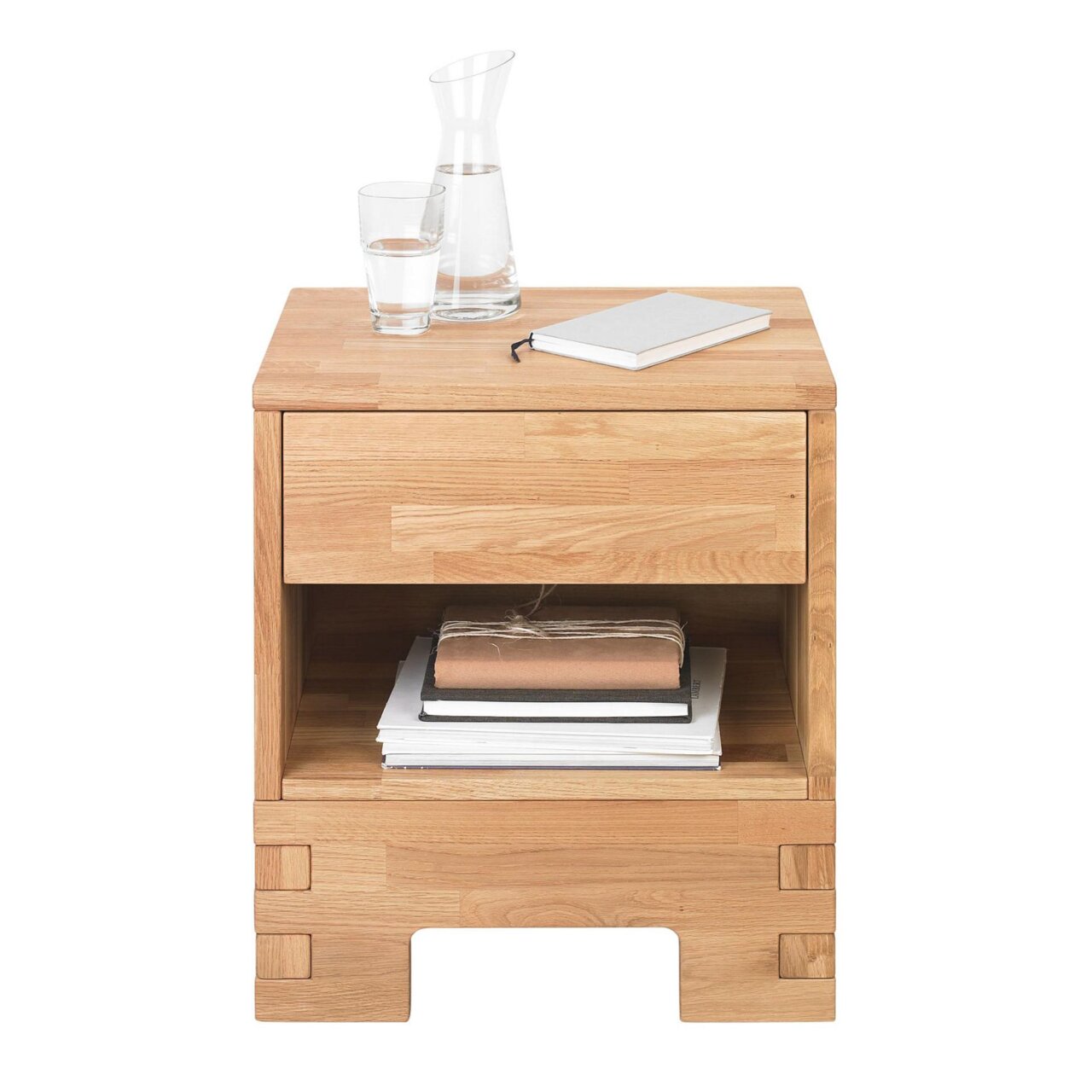 Linea Natura Nachtkommode COUNTRY Nachtkommode aus Holz mit Schublade und offenem Fach, frontal fotografiert, dekoriert mit einer Karaffe, einem Glas Wasser und einem Notizbuch.