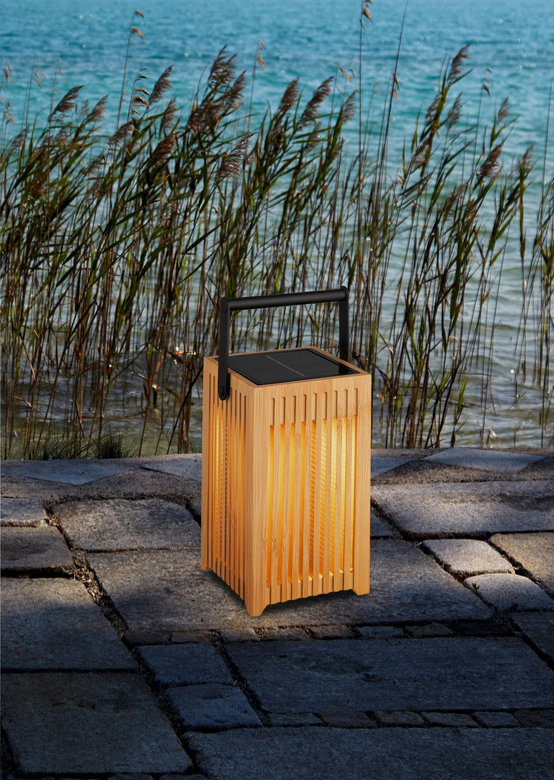 Solarbetriebene Holzlaterne mit Griff, auf einer Steinfläche am Wasser platziert, seitliche Perspektive.