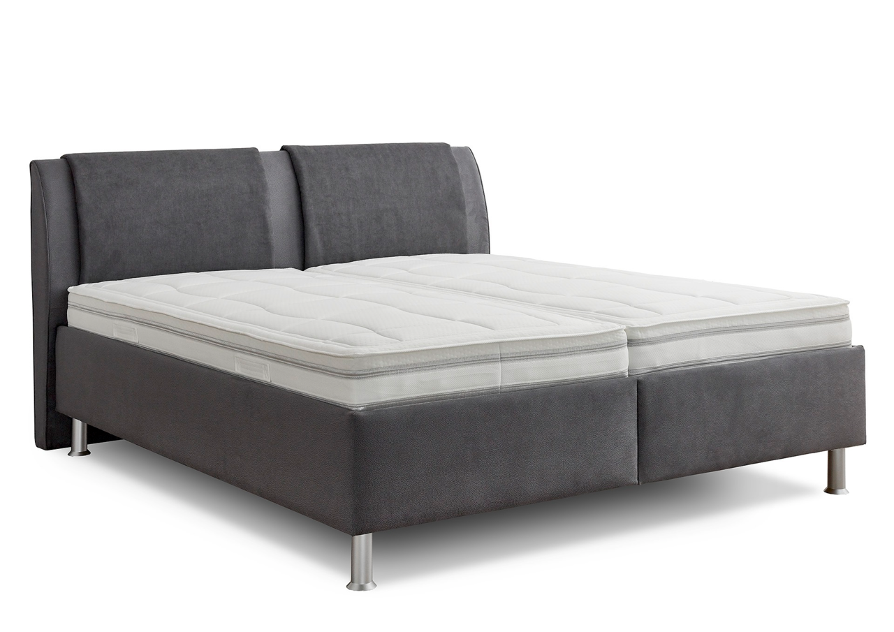 Graues Polsterbett mit hohem Kopfteil und silbernen Füßen, seitliche Perspektive
