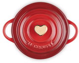 Obenansicht einer roten Le Creuset Mini-Cocotte mit herzförmigem goldenen Knauf, Teil der HEART COLLECTION.