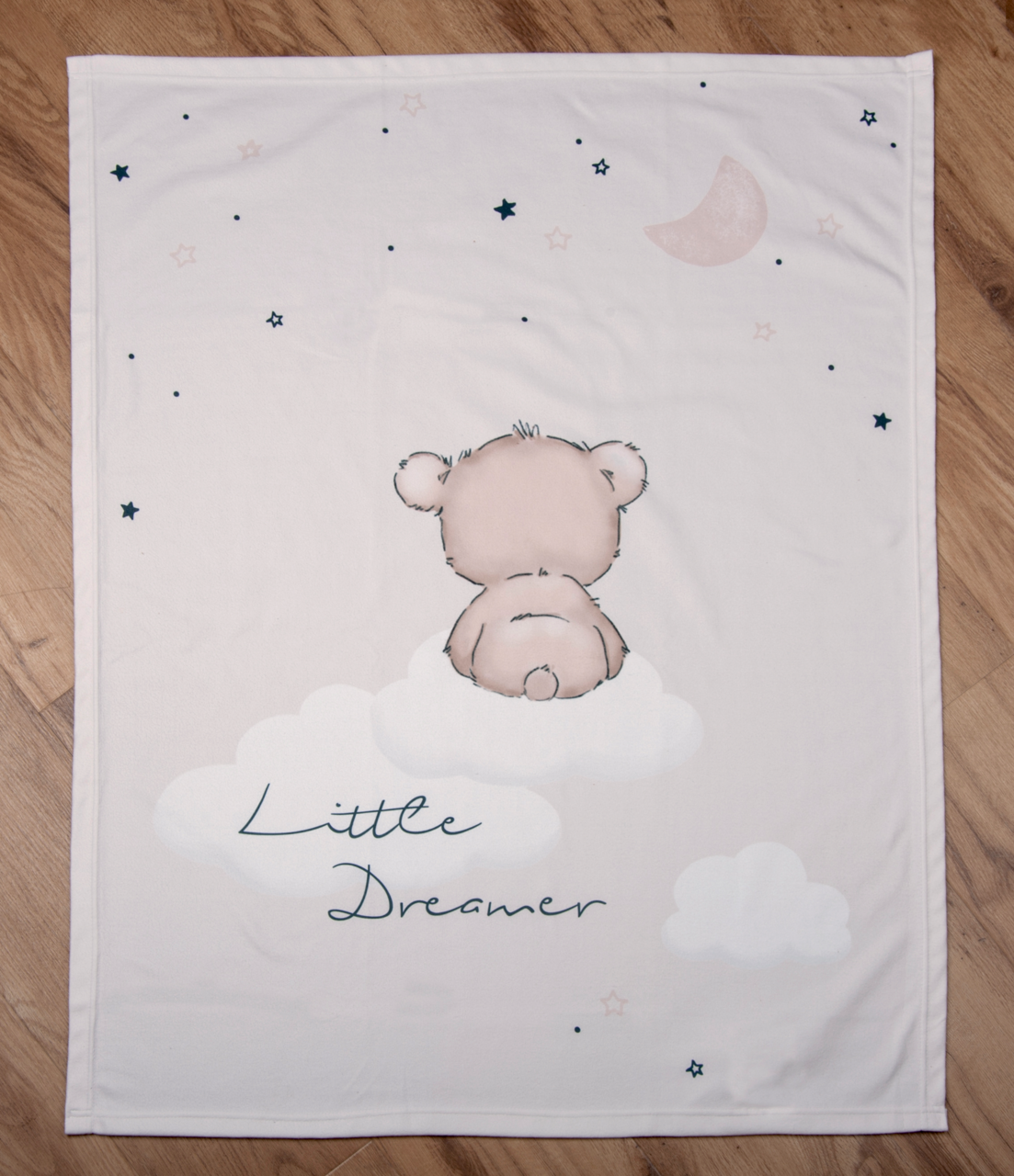 Herding Dekentje van zacht perzikfluweel LITTLR DREAMER Weiche Decke mit einem niedlichen Bärenmotiv, der auf einer Wolke sitzt, umgeben von Sternen und dem Mond. Perspektive von oben.