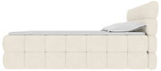 Beiges, gepolstertes Polsterbett mit hohem, segmentiertem Kopfteil und Matratze, seitliche Ansicht (Profil) vor weißem Hintergrund