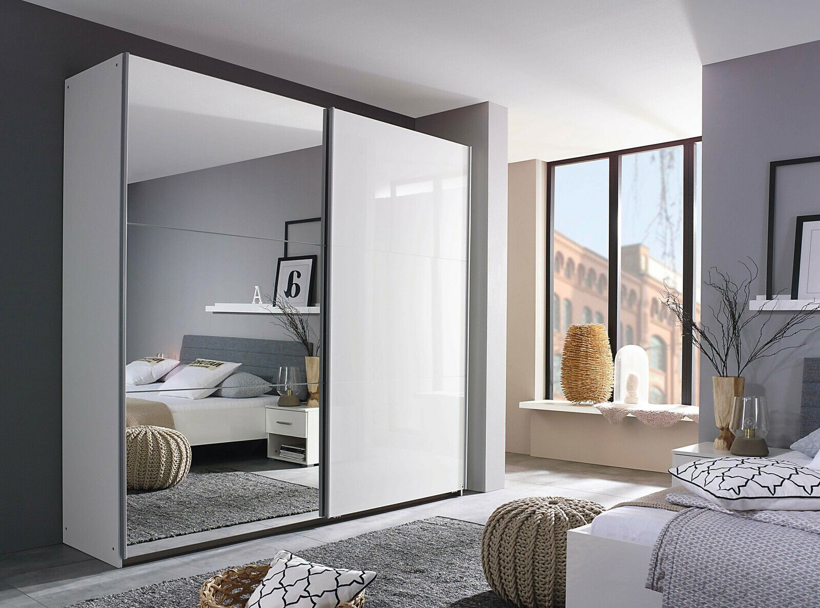 Moderner Schwebetürenschrank mit zwei Türen, eine davon mit Spiegel, in einem stilvoll eingerichteten Schlafzimmer. Perspektive von schräg vorne.