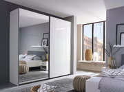 Moderner Schwebetürenschrank mit zwei Türen, eine davon mit Spiegel, in einem stilvoll eingerichteten Schlafzimmer. Perspektive von schräg vorne.