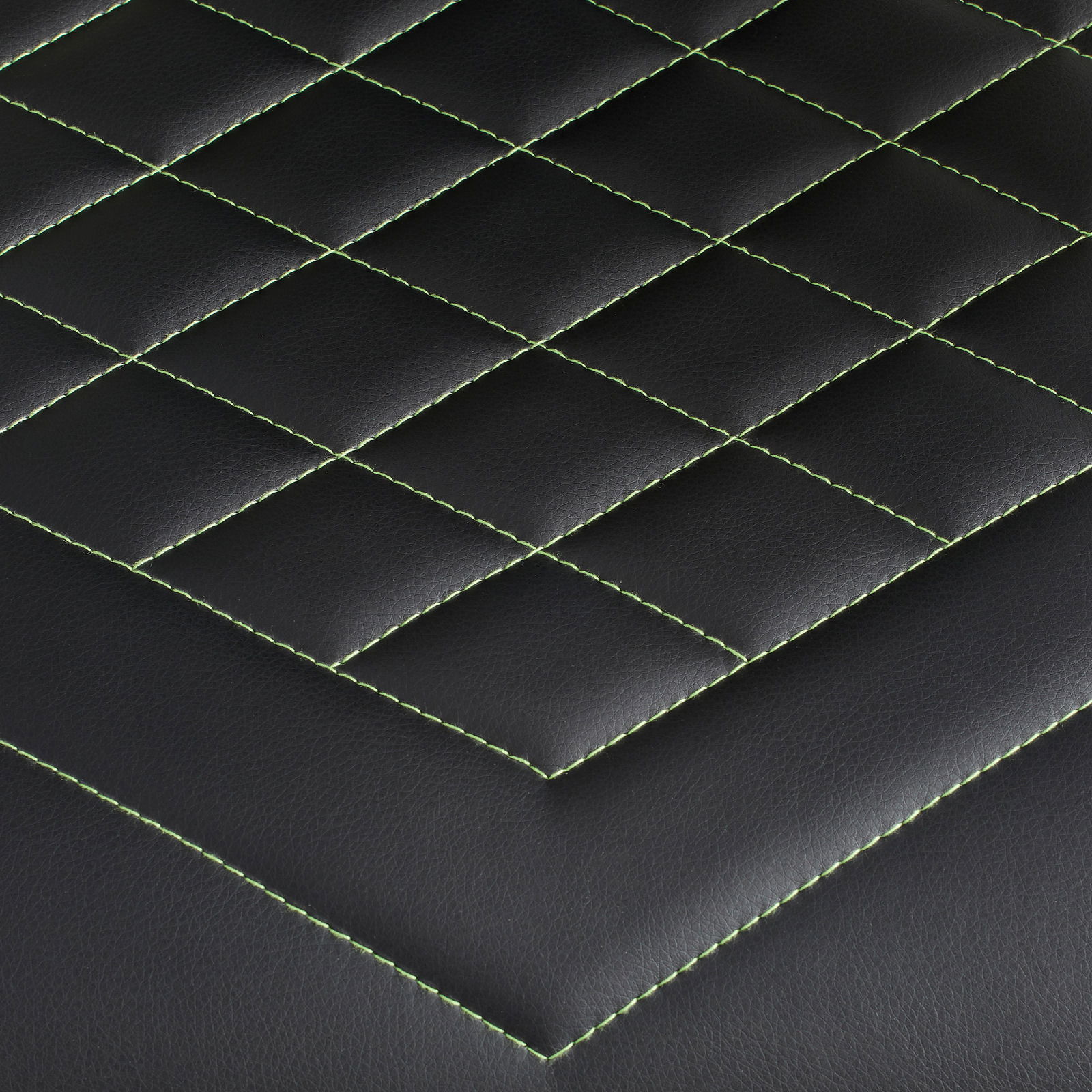 Nahaufnahme der schwarzen Polsterung eines Gaming-Stuhls mit grünen Nähten in Rautenmuster, Draufsicht.