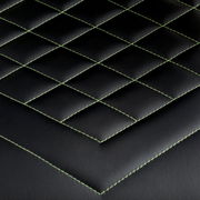 Nahaufnahme der schwarzen Polsterung eines Gaming-Stuhls mit grünen Nähten in Rautenmuster, Draufsicht.