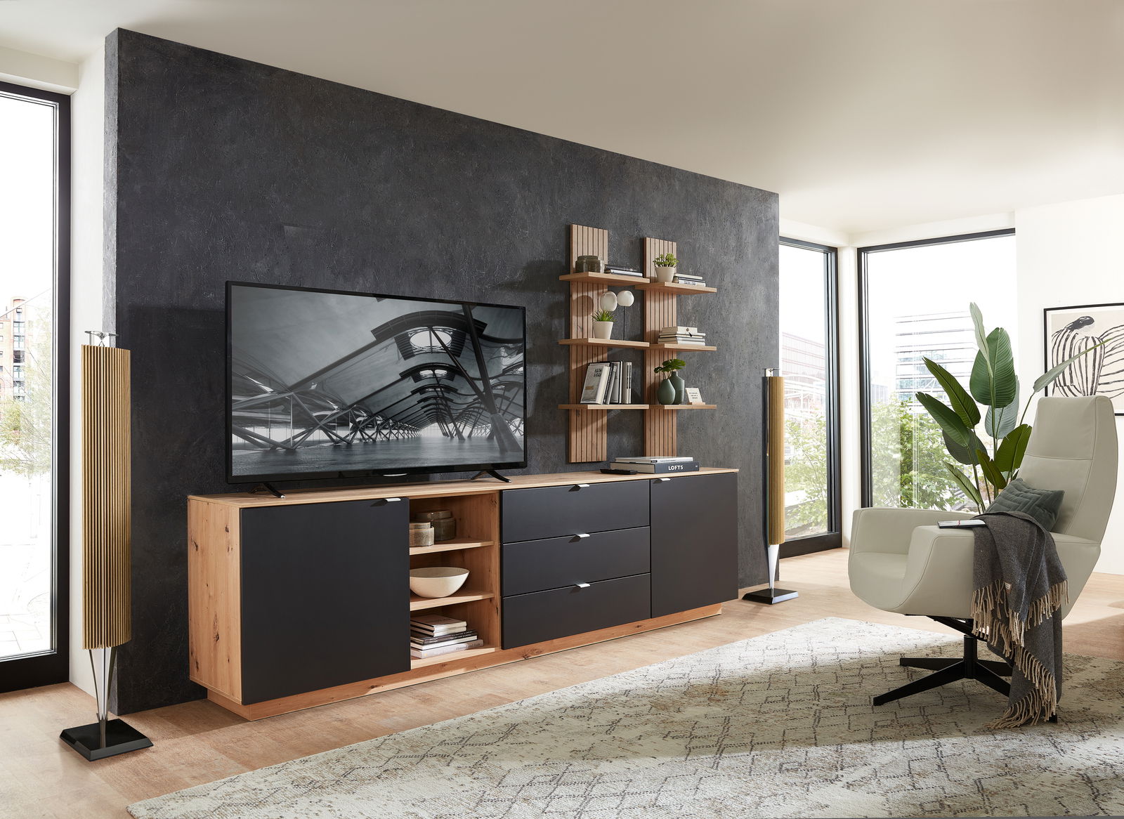 Modernes Wohnzimmer mit einem eleganten Wandpaneel in Holzoptik, das als Hintergrund für ein TV-Gerät und ein Regal mit Dekorationen dient. Perspektive von vorne.