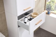 Hochschrank mit geöffneter Schublade, die einen Föhn und einen Korb zeigt, seitliche Perspektive