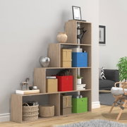Stufenförmiges Regal in Eiche-Optik mit offenen Fächern, dekoriert mit Aufbewahrungsboxen und Dekoobjekten im Wohnzimmer; Perspektive: leicht schräg von vorn.